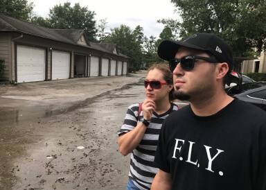 Jo Angel Hernandez and his sister look over their mother’s flooded home. Jo helped at least 30 residents save their vehicles as his own apartment flooded